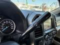 The interior of a 2019 Ford F-550 featuring a steering wheel with gear shift controls a speedometer and a touchscreen display