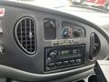 Interior dashboard of a 2006 Ford Econoline showing climate controls radio and a warning label about the parking brake
