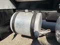 A metallic air tank with a smooth surface and attached pipes secured by black straps mounted on the side of a 2008 Peterbilt 340 truck
