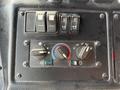 Close-up of the control panel in a 2010 Autocar Xpeditor featuring various knobs and switches for locking and climate control