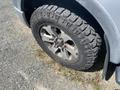 A close-up of a tire on a 2014 Ford F-150 showing a rugged tread pattern and aluminum alloy wheel