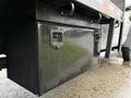 A black storage box mounted underneath a truck with metal latches and a textured surface