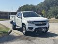 A white 2017 Chevrolet Colorado pickup truck with a blue toolbox in the bed and a front-mounted winch