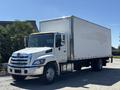 A white 2020 Hino 338 box truck with a large cargo area and chrome accents parked on a concrete surface