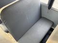 A gray bench seat with a smooth surface and a single cushion, designed for passenger use in a vehicle, showing signs of wear and minimal texture
