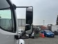 A 2006 Freightliner M2 106 with a prominent side mirror showcasing a reflection of nearby vehicles