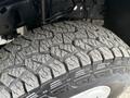 Close-up of a rugged tire tread on a 2001 Ford F-350 featuring deep grooves and patterns designed for traction on various surfaces