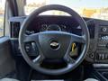 Steering wheel of a 2019 Chevrolet Express with a silver Chevy logo in the center and various controls on the hub