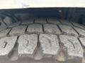 Close-up of a tire tread on a 2013 Freightliner 114SD showing deep grooves and wear patterns indicating heavy use