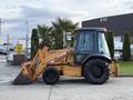 A 2005 Case 570 backhoe loader with a yellow and black exterior featuring a front loader bucket and rear excavator arm