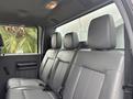 The interior of a 2014 Ford F-550 showing the rear seat with gray leather upholstery and headrests