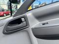 Interior door handle of a 2022 Isuzu NQR showing a gray textured surface with a small window control button