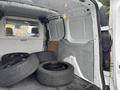 A 2019 Ford Transit Connect van interior with four black tires stacked inside