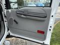 2007 Ford F-450 truck door with a gray interior panel featuring a handle a speaker grill and a red light near the bottom