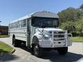 A 2009 International 3000 CE school bus with a white exterior and a chrome front grille featuring a push bar and large tires