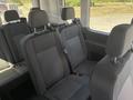 Interior seating of a 2025 Ford Transit T-350 with multiple dark fabric seats and headrests arranged in two rows