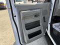 The interior door panel of a 2021 Ford Econoline featuring a gray design with a handle and storage compartments