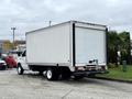 A 2022 Ford E-450 box truck with a white cargo area and a black rear door parked at an angle