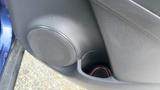 A close-up view of a speaker and cup holder inside the door panel of a 2019 Nissan Kicks
