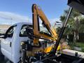 A 2008 Ford F-550 truck equipped with a hydraulic crane arm mounted on the bed for lifting and loading heavy materials