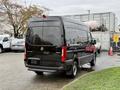 A 2022 Mercedes-Benz Sprinter van with a black exterior viewed from the rear angle showing its sleek design and large cargo space