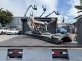 A 2016 RAM 5500 truck with a flatbed equipped with a mounted equipment arm used for lifting and maneuvering heavy loads