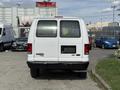 A white 2013 Ford Econoline van viewed from the rear with a black bumper and a blank license plate area
