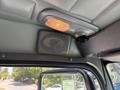 The interior of a 2008 Peterbilt 340 featuring a speaker light and an interior light mounted on the ceiling with a visible window view