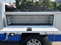 A 2017 Chevrolet Colorado with an open truck bed featuring a lined storage compartment and a pair of tie-downs visible inside the bed