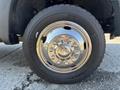 Close-up of a silver wheel rim with shiny bolts mounted on a black tire labeled Michelin P265/70R17