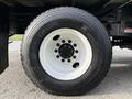 Close-up of a Michelin X tire mounted on a white rim with visible lug nuts showcasing the tread pattern and surface details