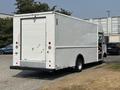 A white 2018 Ford Econoline van with a boxy shape and a rear cargo door parked on the street