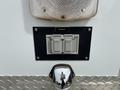 A close-up of an outlet panel on a vehicle with two gray outlets labeled #5 and a silver connection point below it