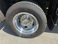 A close-up of a shiny chrome wheel with a tire from a 2011 Dodge Ram 5500 featuring a tread design and visible lug nut pattern