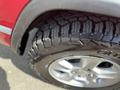 Close-up of a tire on a 2015 Jeep Grand Cherokee showing rugged tread pattern and alloy wheel