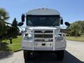 A white 2009 International 3000 CE school bus with a prominent front grill and multiple mirrors is parked, displaying its large windshield and distinctive headlights
