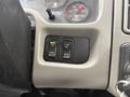 Close-up of two control buttons in a vehicle dashboard labeled Work Light and Fan with green indicator lights showing they are on