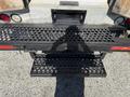 A black metal loading ramp with a perforated surface attached to the rear of a 2009 Morgan Olson Workhorse W62