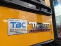 A portion of a yellow school bus featuring the Thomas Built Buses logo and a sticker for TBC The Bus Centre indicating sales parts and service information