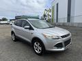 A silver 2015 Ford Escape parked with a sleek design featuring five doors alloy wheels and modern headlights