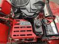 Close-up view of a 2017 Ferris Rotary mower engine showcasing the engine parts battery and control panel with various labels and indicators