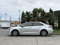 A silver 2025 Toyota Corolla parked with its side facing the viewer showcasing sleek lines and modern design elements