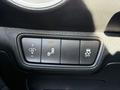A close-up view of the control panel in a 2024 Kia Forte5 featuring three buttons for lights parking assist and traction control