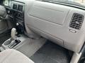 Interior view of a 2004 Toyota Tacoma showing the dashboard gear shift and center console with controls and cup holders