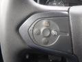 Close-up of a steering wheel control panel on a 2015 Chevrolet Silverado 1500 featuring buttons for cruise control settings