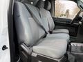 The image shows the front seats of a 2012 Ford F-550 with gray fabric upholstery and seatbelts visibly secured across the seats