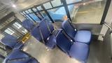Interior view of a 2021 Ford Transit showing blue seats secured with seatbelts arranged in rows