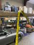 A 2010 Toyota 7FGGU25 forklift is positioned in a warehouse with a measuring tape hanging from a shelf above it
