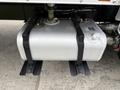 A large silver fuel tank attached to a black metal base under a 2019 Ford F-750 truck