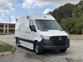 A 2020 Mercedes-Benz Sprinter 2500 van with a white exterior and black accents parked at an angle showcasing its front and side features